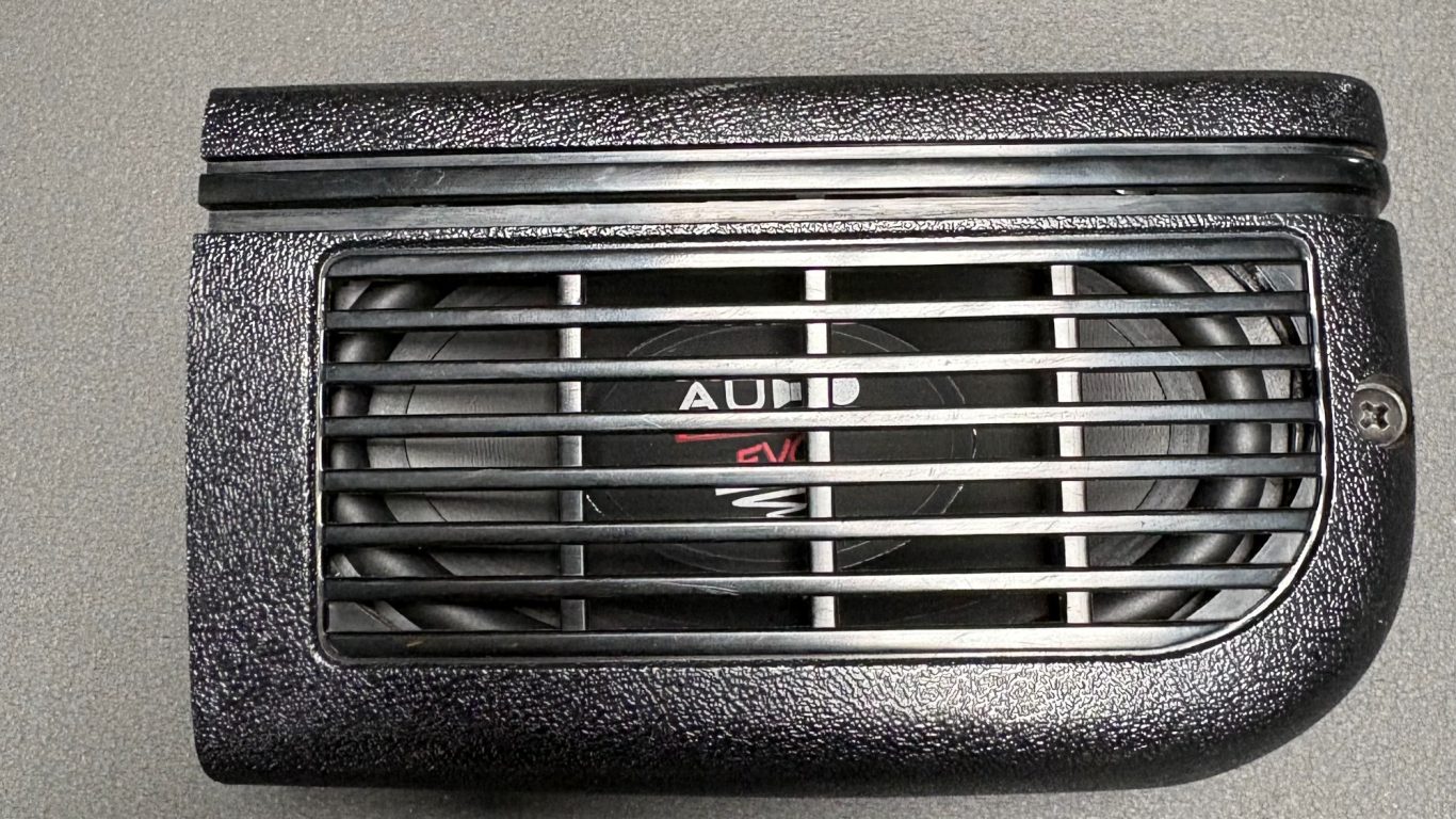Subwoofer mit Abdeckgitter im Kofferraum des VW Golf 1